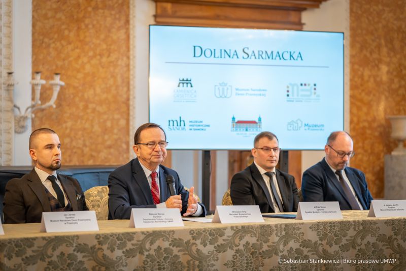 Sala Balowa, goście wydarzenia - powołania do życia Doliny Sarmackiej. Zbliżenie na stół na scenie - 4 mężczyzn.