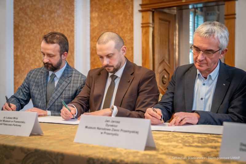 Sala Balowa, dwóch dyrektorów i kierownik podpisujący porozumienie Dolina Sarmacka