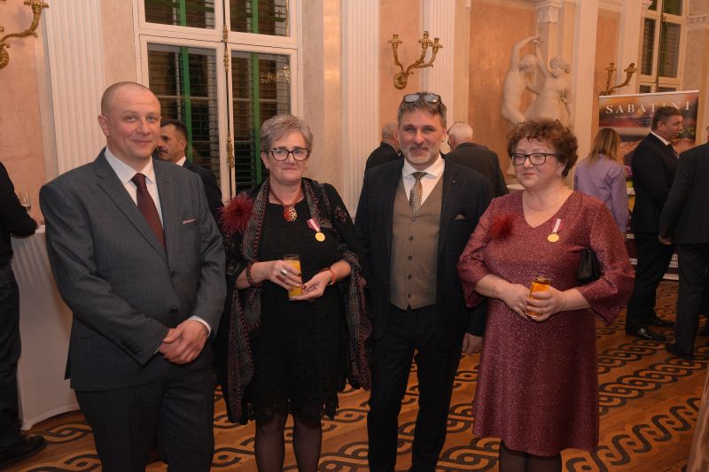 Goście gali pozujący na bankiecie w Wielkiej Jadalni - 2 kobiety i 2 mężczyzn